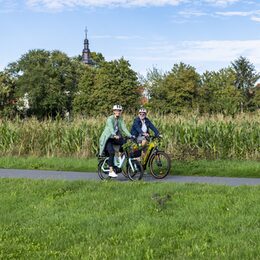 Zwei Radfahrer vor einem Maisfeld